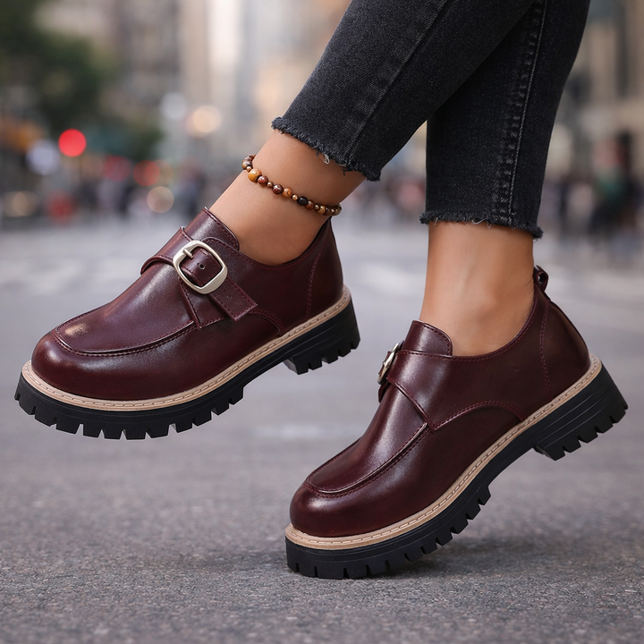 Women's black leather loafers with gold buckle detail, comfortable and stylish flats.