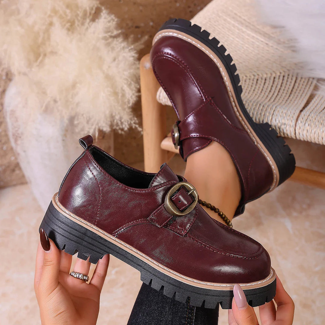 Pair of women's flat leather loafers with decorative buckle, suitable for everyday comfort.