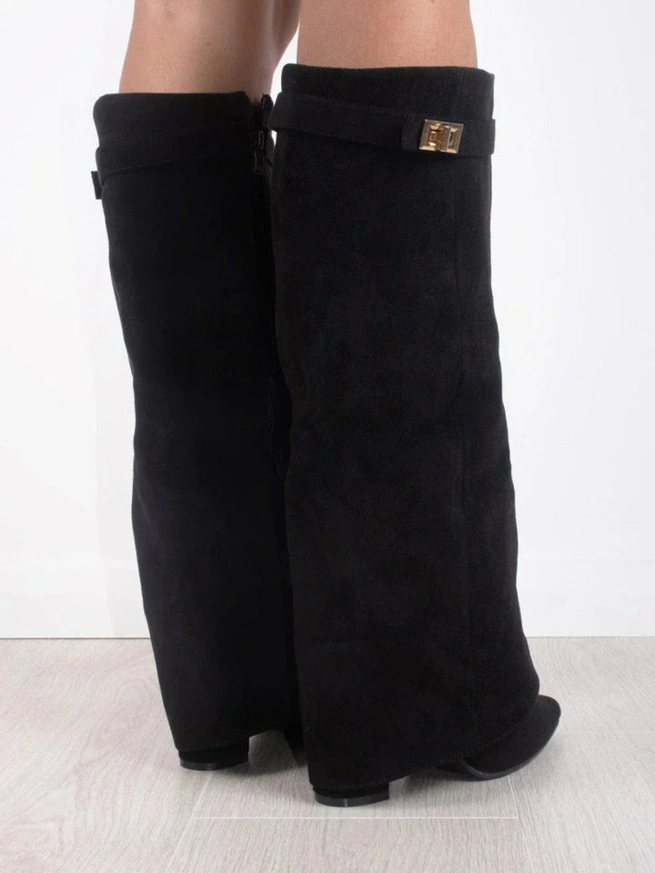 Close-up of the buckle detail on women's elegant leather thigh-high boots, high fashion footwear.