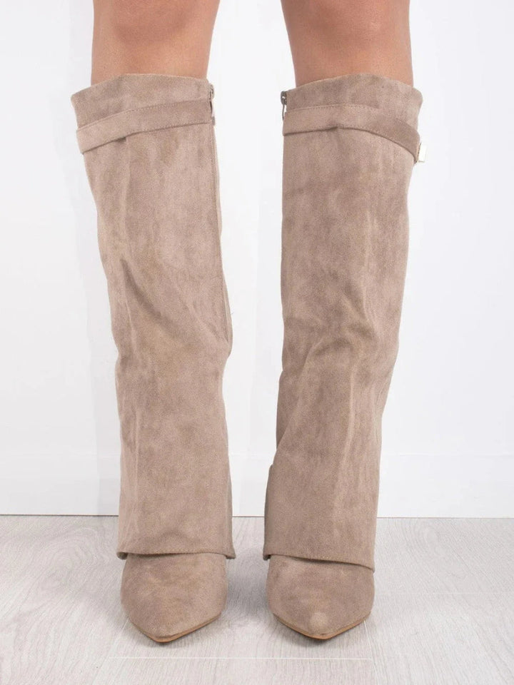 Pair of women's fashion thigh-high leather boots with buckle details, standing against a dark background.