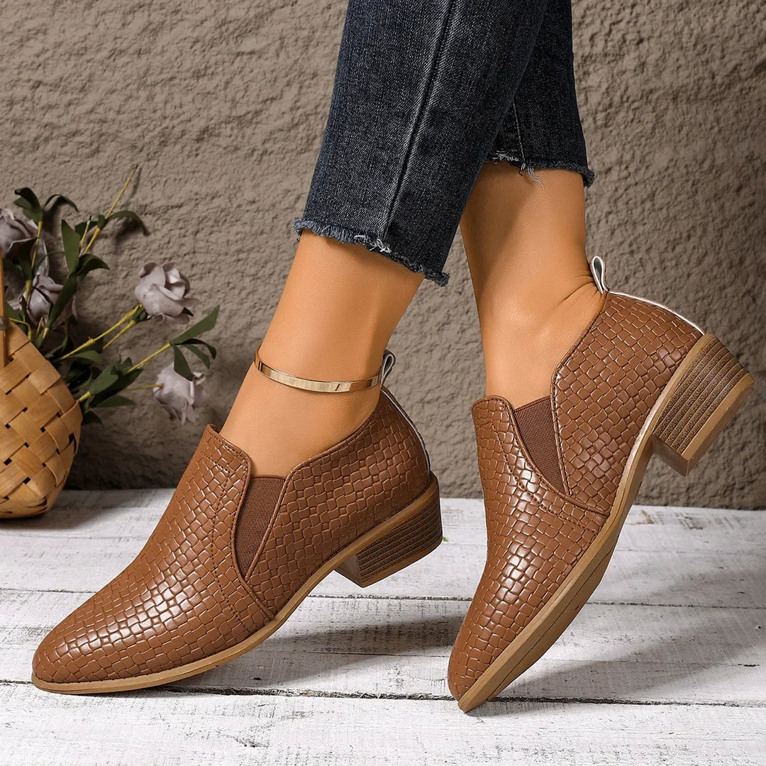 Pair of women's slip-on ankle boots made from braided leather, offering both comfort and modern style.