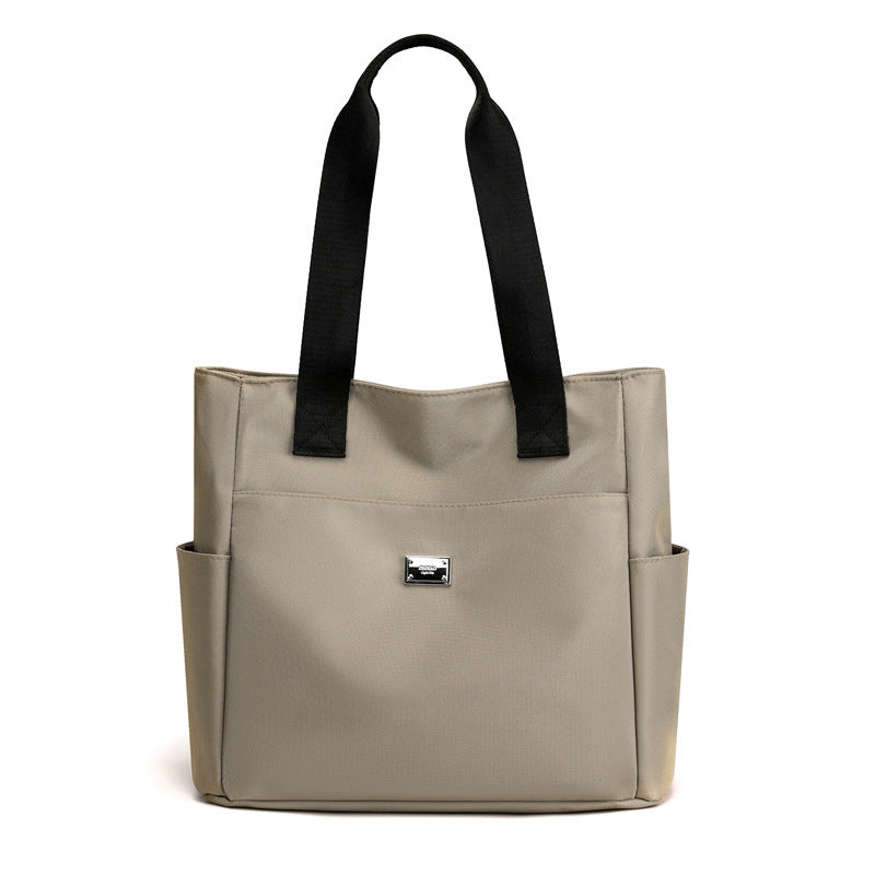 Zoomed shot of the multi-pocket detail on the front of the women's waterproof nylon shoulder bag