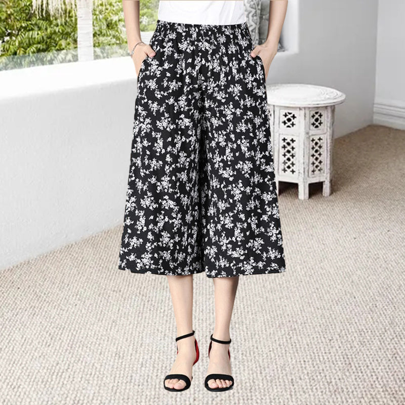 Black women's culottes with a high elastic waist, wide leg, and pleats, combining comfort and style.