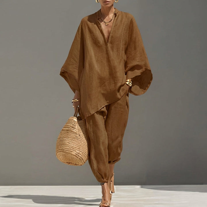 Minimalist black women's two-piece set: an oversized tunic and tapered pants for a modern, relaxed look.