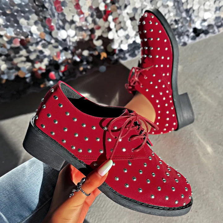 Stylish women's studded oxfords, black leather with lace-up design, offering both comfort and a trendy look.
