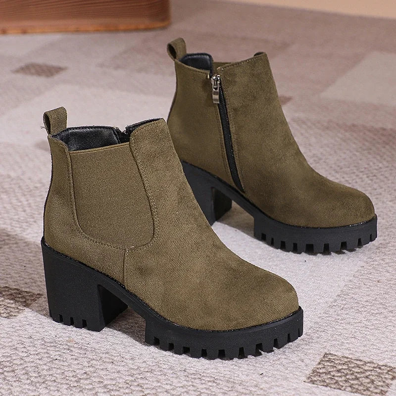 Detail of the block heel on a women's burgundy suede ankle boot, offering stability and style