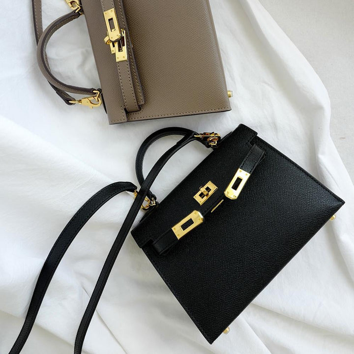 Classic brown women's shoulder bag with turn lock. Top handle & adjustable strap. Elegant, structured handbag. Fashion accessory.
