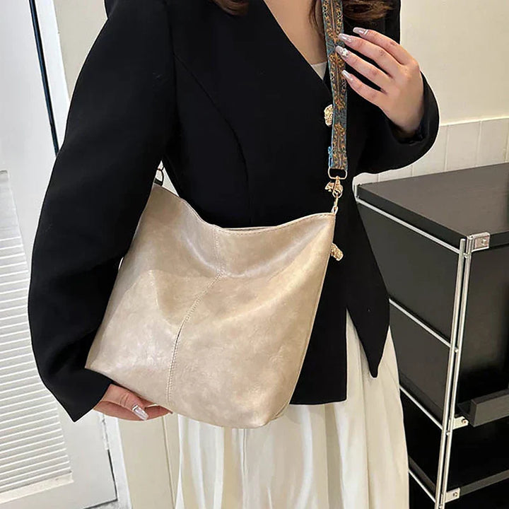 Faux leather slouchy bohemian shoulder bag for women, featuring a vibrant patterned strap.