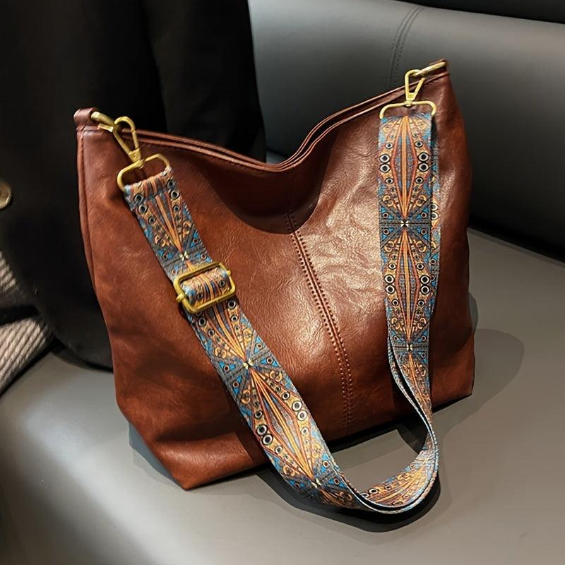Slouchy faux leather women's bohemian shoulder bag with an intricate patterned strap, versatile accessory.