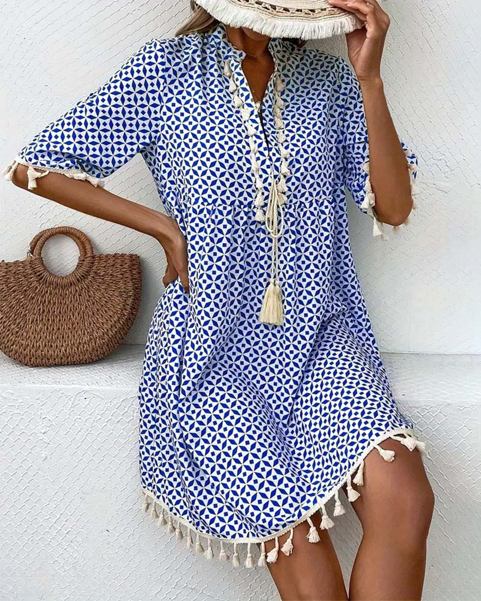 Casual women's boho mini dress featuring a geometric pattern & tassel trim, ideal for beach vacations.