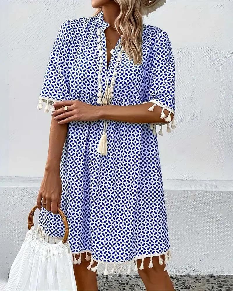 Chic women's boho mini dress with intricate geometric patterns, V-neck, and fun tassel hem for resort wear.