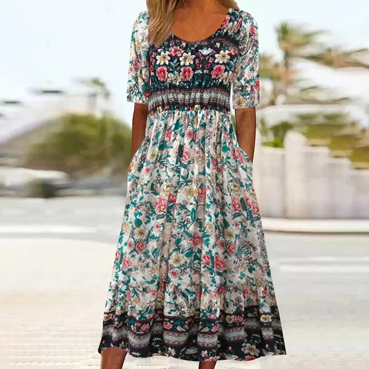 Flattering women's boho floral print midi dress. Features a gathered waist, short sleeves, round neck, and convenient pockets.