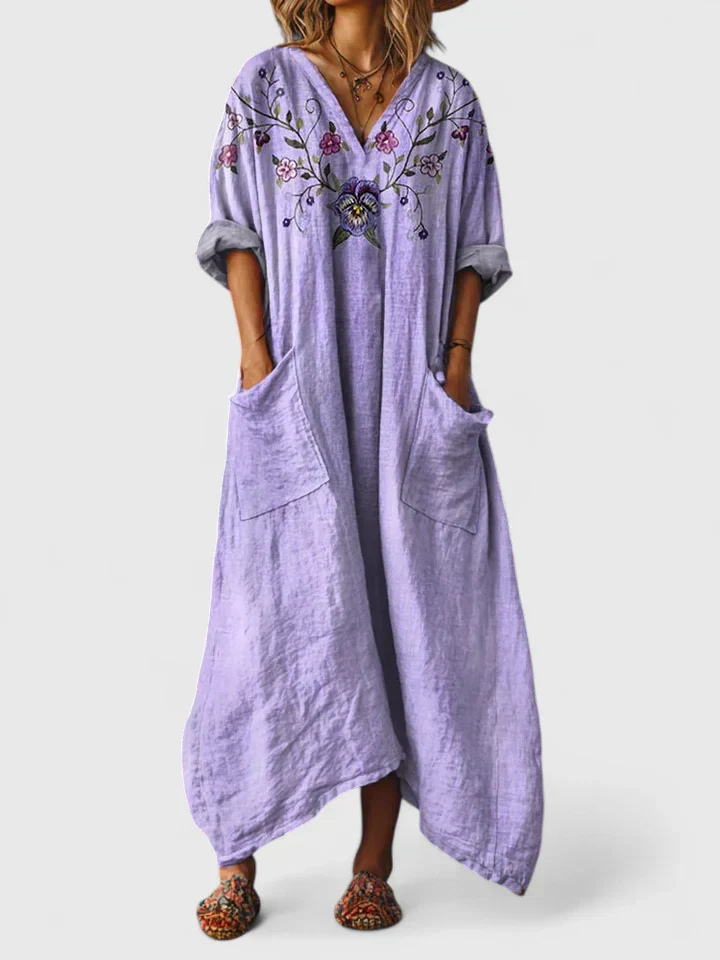 Bohemian style women's maxi dress with a captivating print, V-neck, 3/4 sleeves, and practical front pocket for comfort.