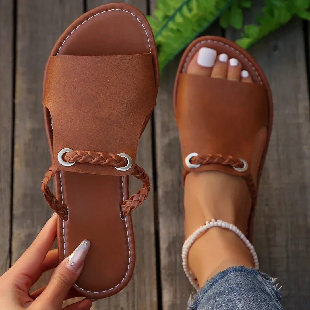 Stylish women's slip-on flat sandals with intricate braided strap detail
