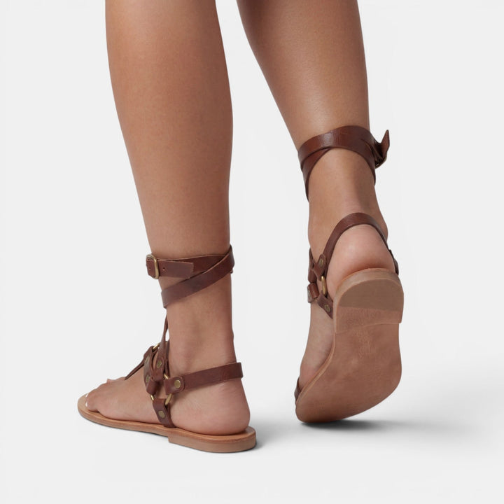 Comfortable women's snake print flat sandals featuring buckled crossover straps for all-day wear.