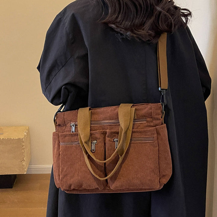 Detailed shot of the stitching and hardware on a women's corduroy shoulder bag, showcasing quality.