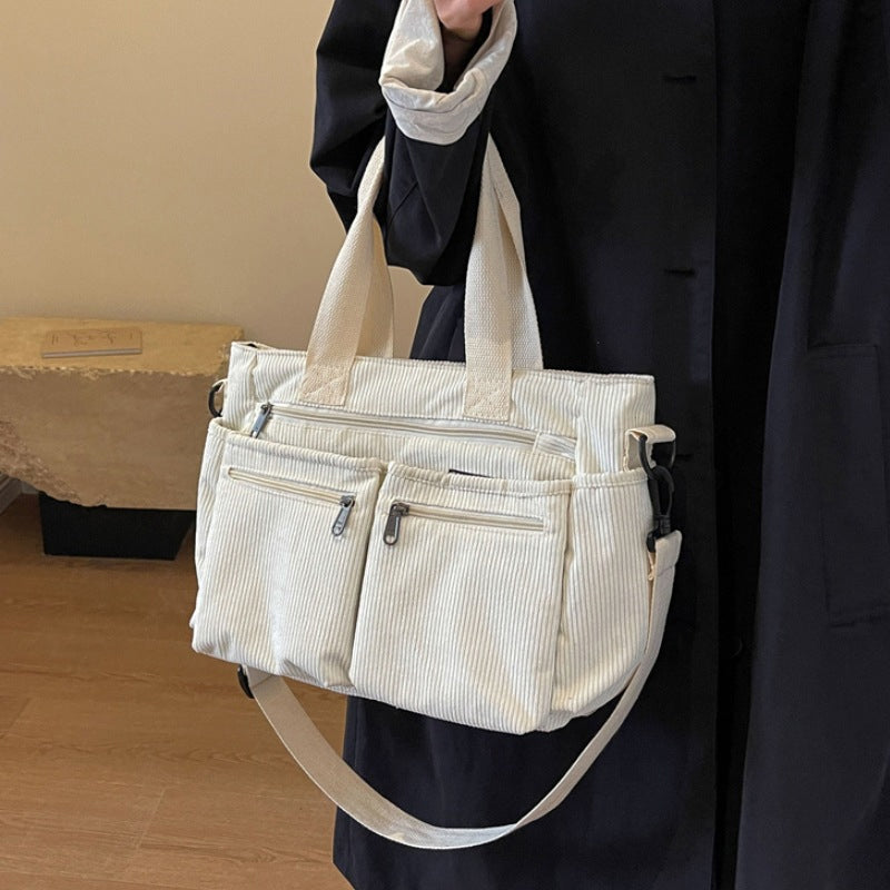 Elegant women's corduroy shoulder bag with sturdy handles, perfect for a refined casual look.