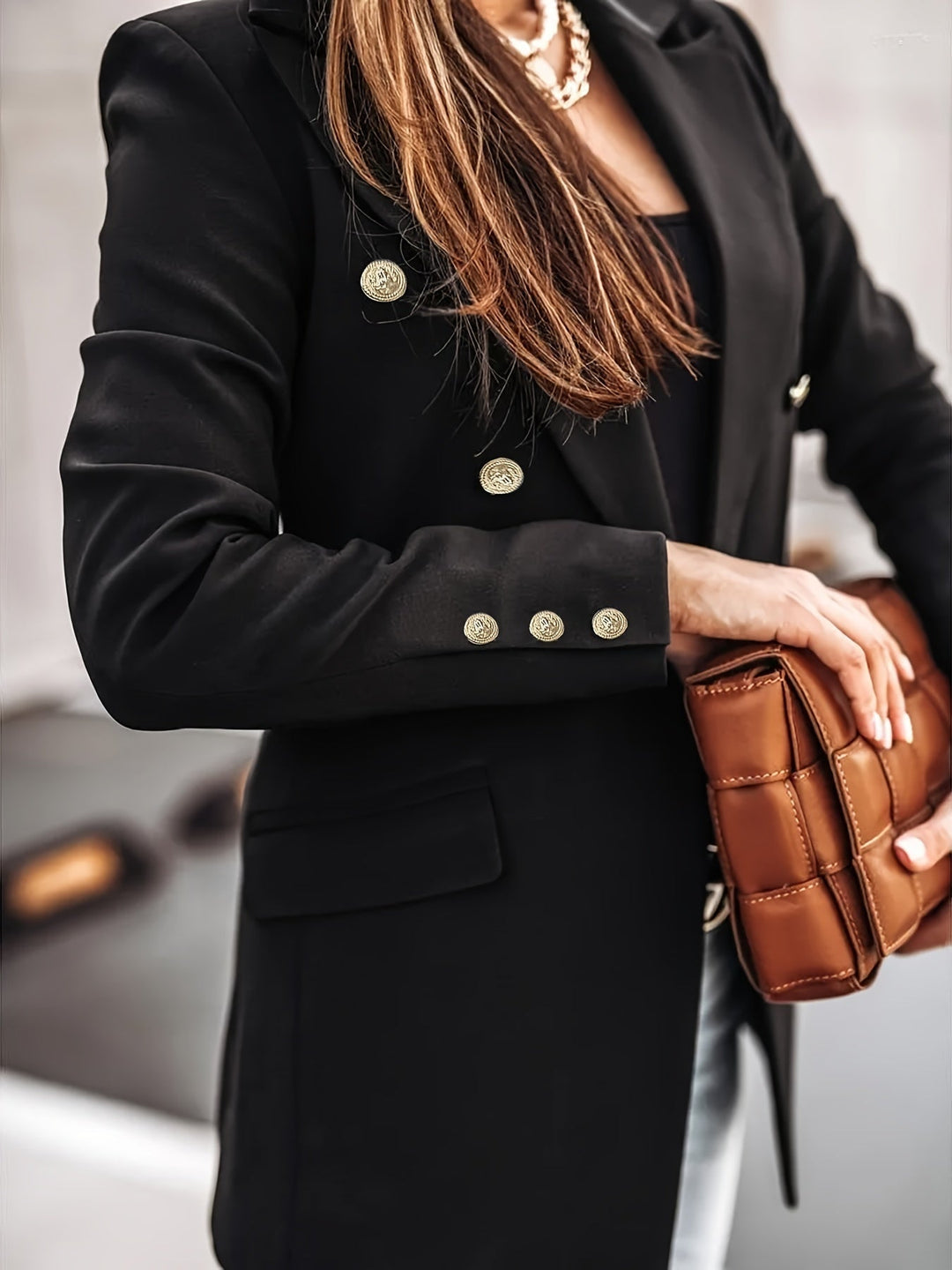Casual chic women's double-breasted blazer with prominent buttons, suitable for diverse occasions.