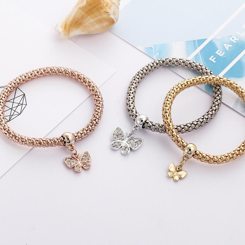 Close-up of a women's popcorn chain bracelet set with multiple rhinestone charms, fashion accessory