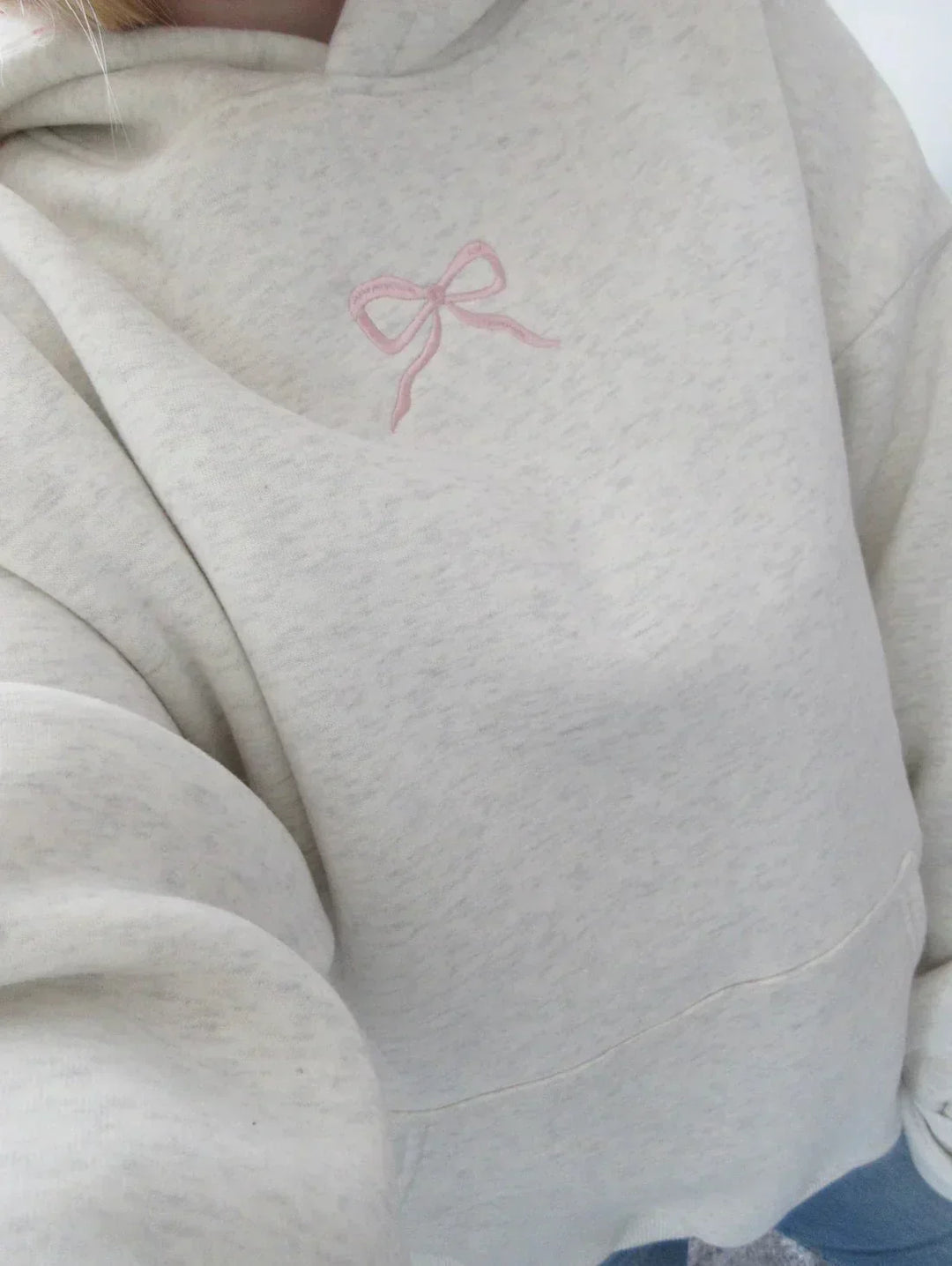 Women's chic hoodie with elegant bow detail, comfortable relaxed fit, and practical drawstring hood.
