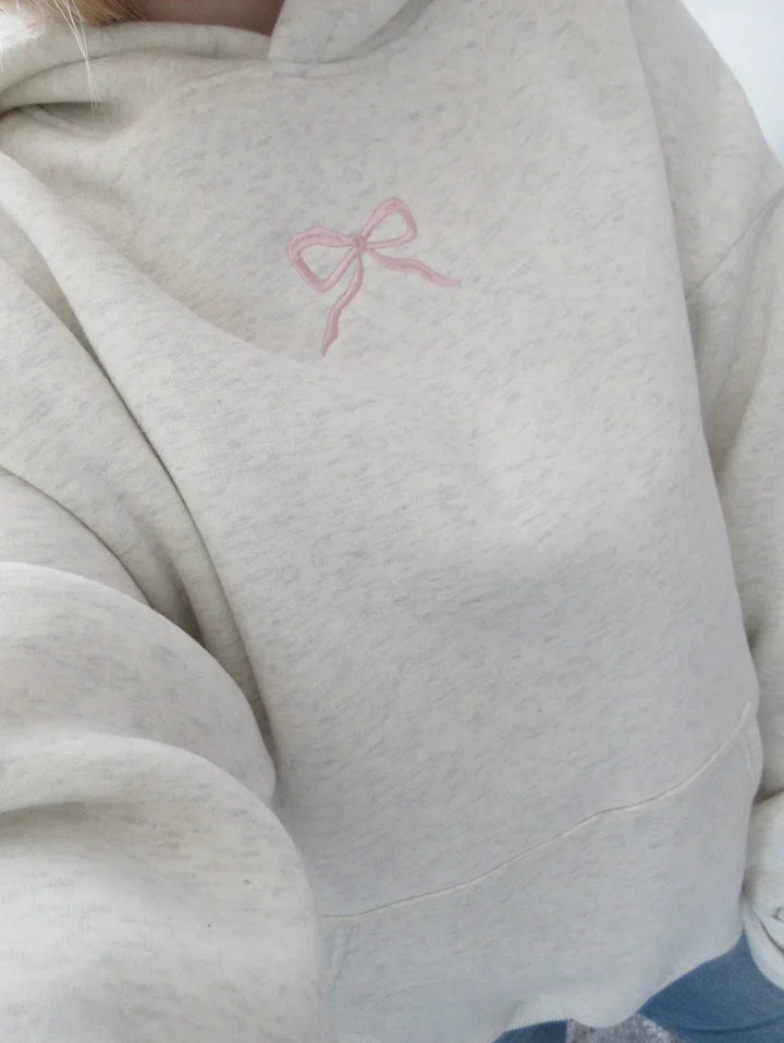 Women's chic hoodie with elegant bow detail, comfortable relaxed fit, and practical drawstring hood.