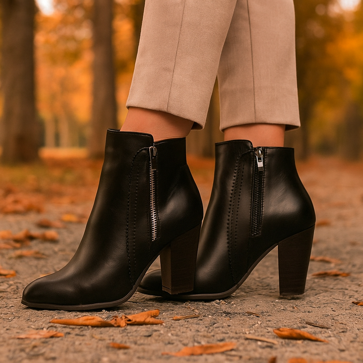 Pair of black women's ankle boots with scalloped trim, side zipper, and comfort features for winter wear.