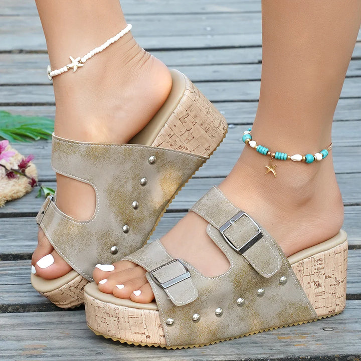 Side view of a women's grey comfortable buckle slide sandal, showcasing the wedge and adjustable straps.