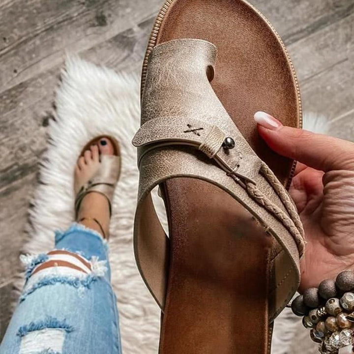 Front view of women's comfortable open-toe slip-on sandals in a light color