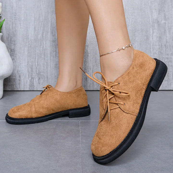 Top-down view of stylish women's lace-up suede flats, emphasizing the design.