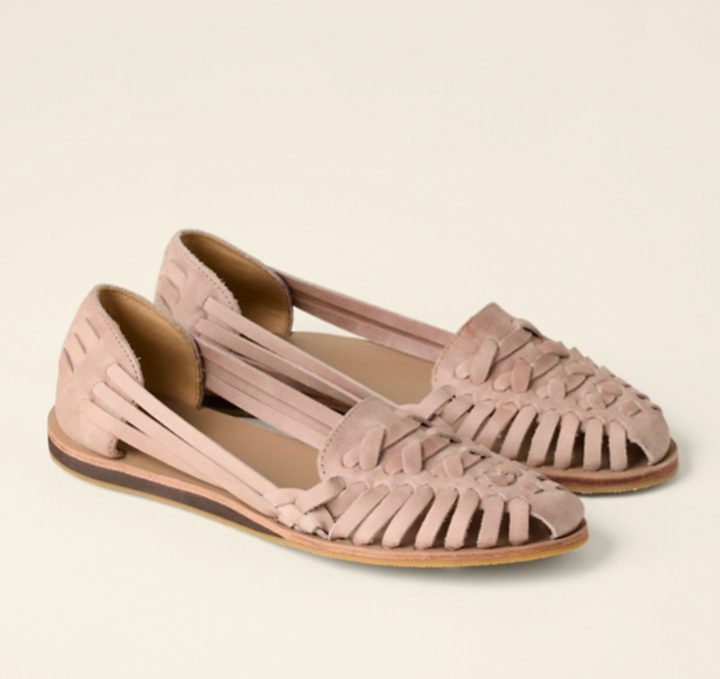 Stylish women's slip-on flat sandals with intricate woven straps & adjustable buckle, ideal for casual summer outfits.