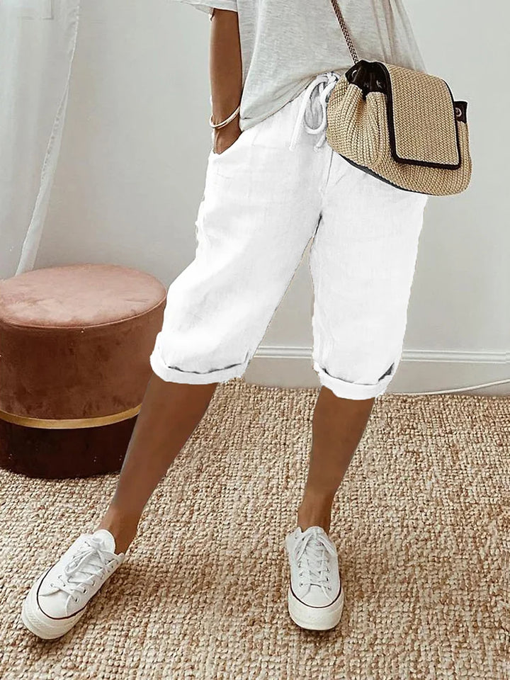 Soft cotton women's capri pants with drawstring waist, roll hem, & practical pockets. Relaxed summer wear.