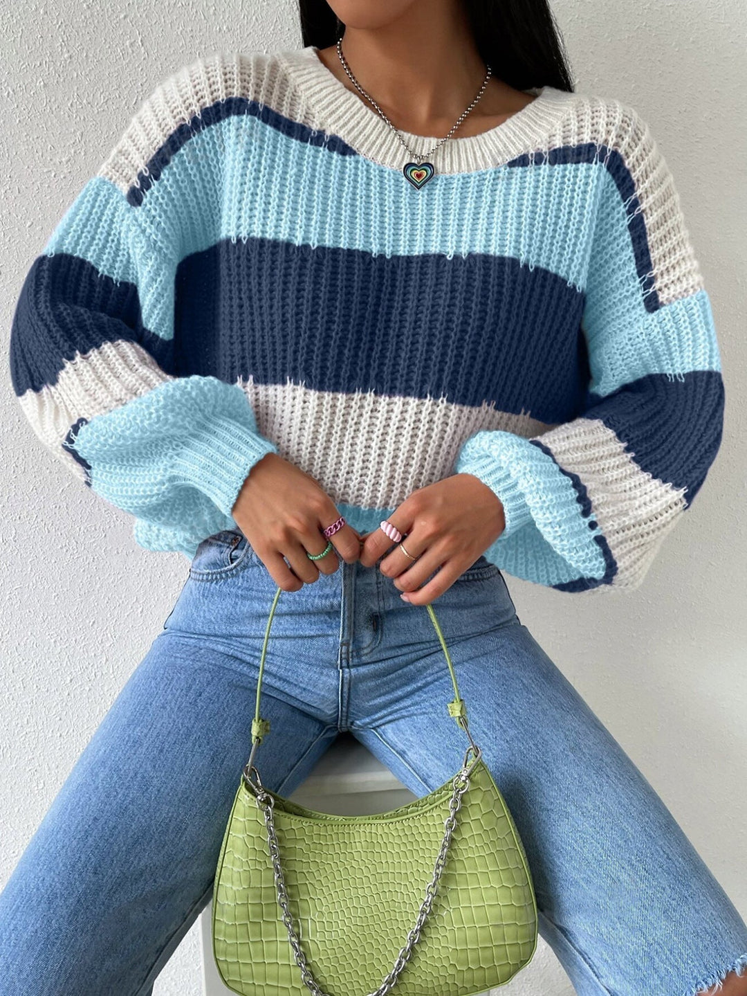 Detailed image of the hem and sleeve cuffs of a women's striped knit pullover sweater, highlighting quality.