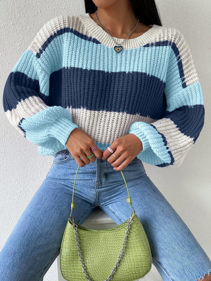 Detailed image of the hem and sleeve cuffs of a women's striped knit pullover sweater, highlighting quality.