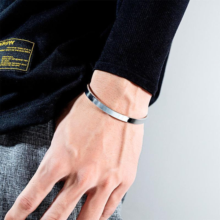 Side view of women's adjustable stainless steel cuff bracelet, 'Crown' word engraved for inspiration
