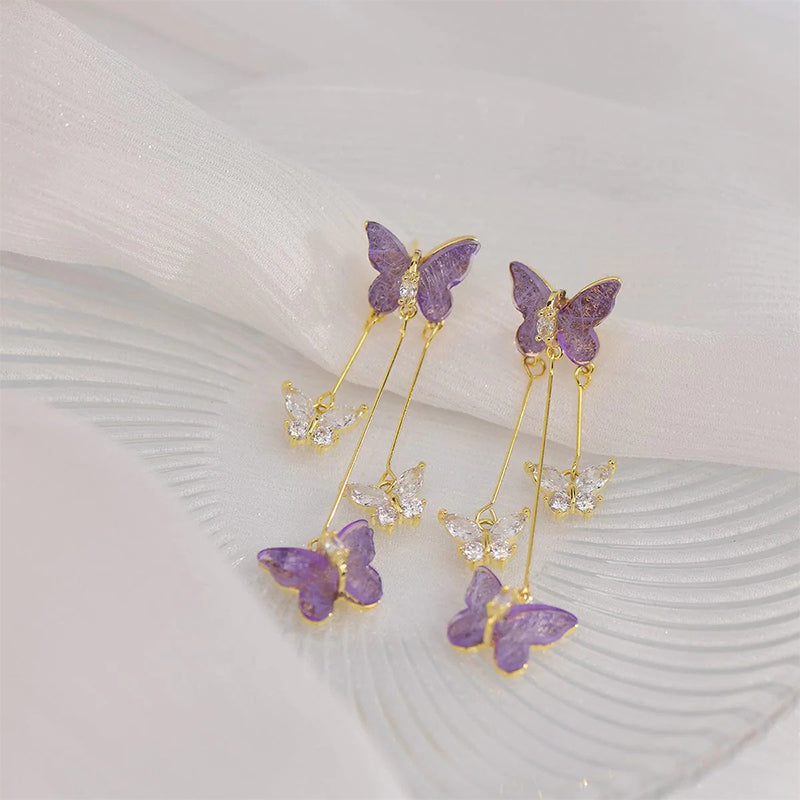 Close-up of women's crystal butterfly dangle earring with intricate rhinestone details, long tassel
