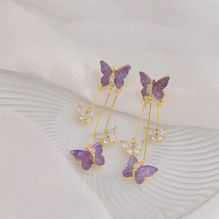 Close-up of women's crystal butterfly dangle earring with intricate rhinestone details, long tassel