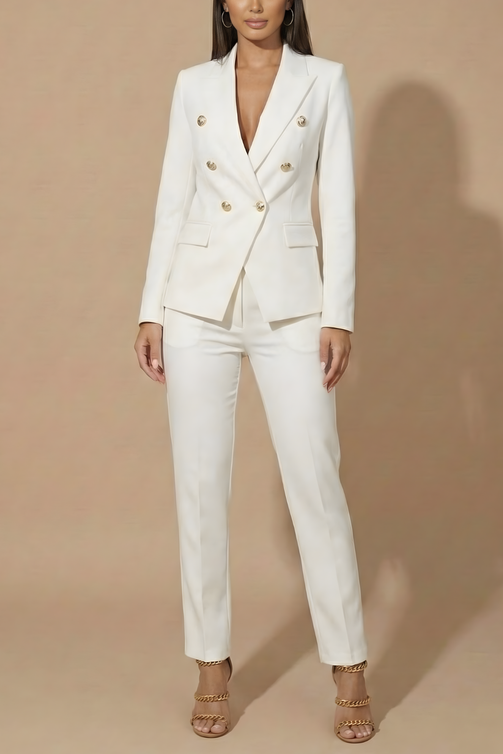 Chic women's double-breasted suit with gold buttons, pairing a blazer and tailored trousers.