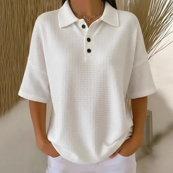 Comfortable women's short sleeve waffle knit polo blouse with a relaxed fit and stylish button neck.