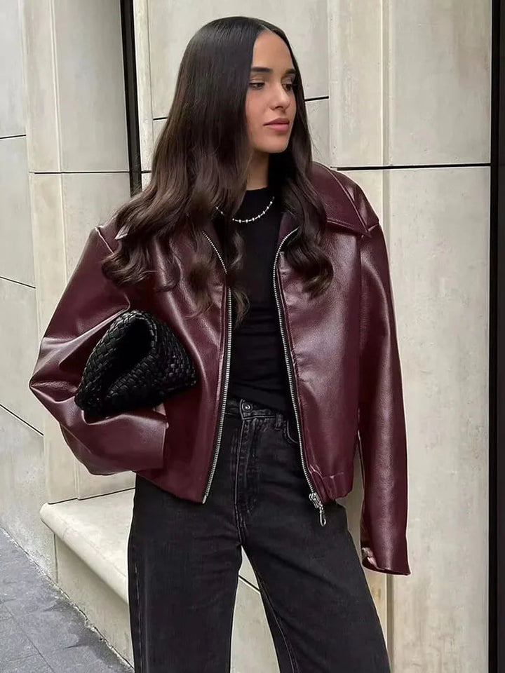 Tailored burgundy leather jacket with zipper for women. Versatile chic outerwear, ideal for spring and autumn styles.