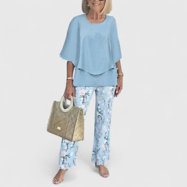 Complete women's elegant floral two-piece outfit with stylish layered top & wide leg trousers.