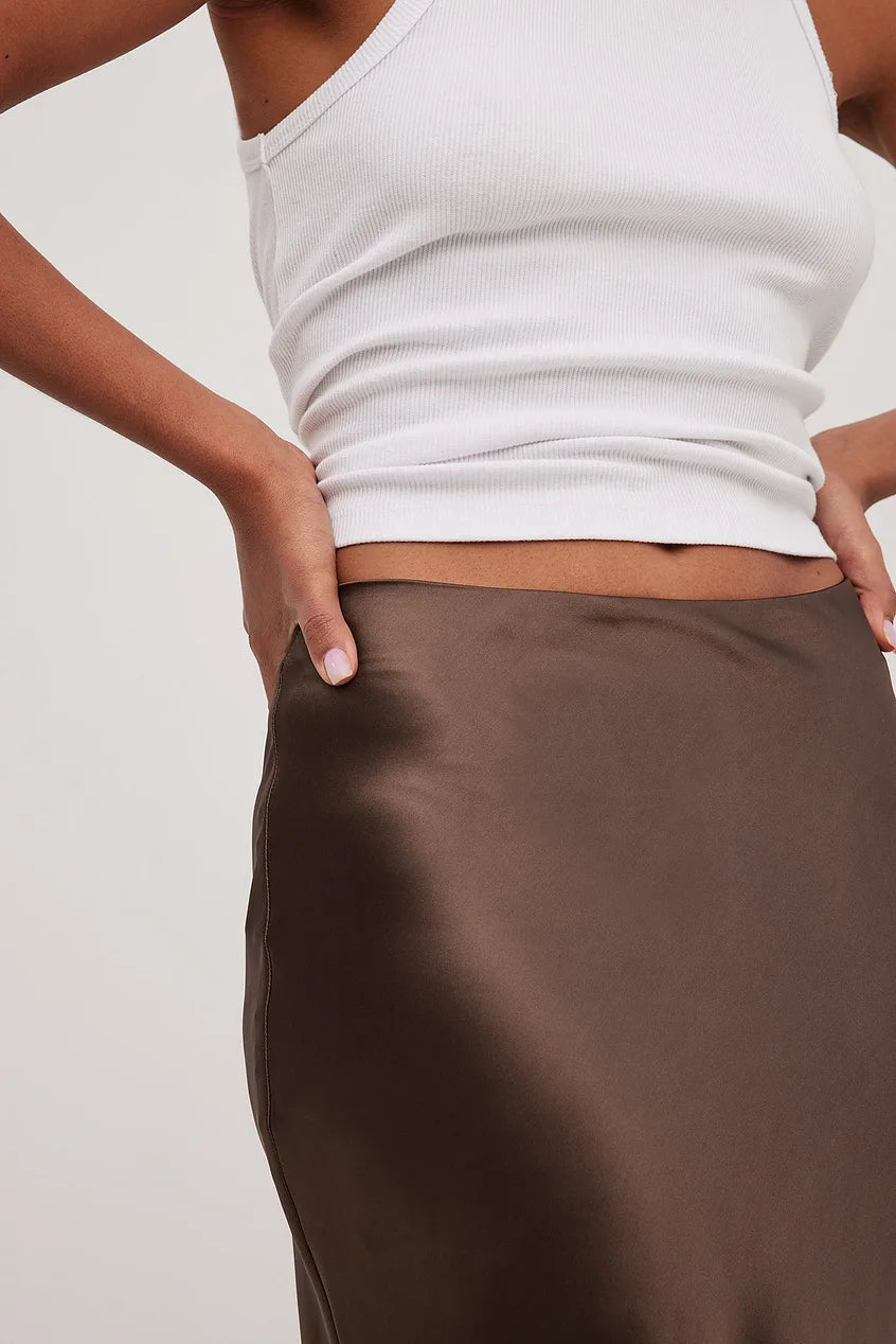 Close-up: Detail of the elegant high-waisted flowing midi skirt, showcasing flowing fabric and finish.