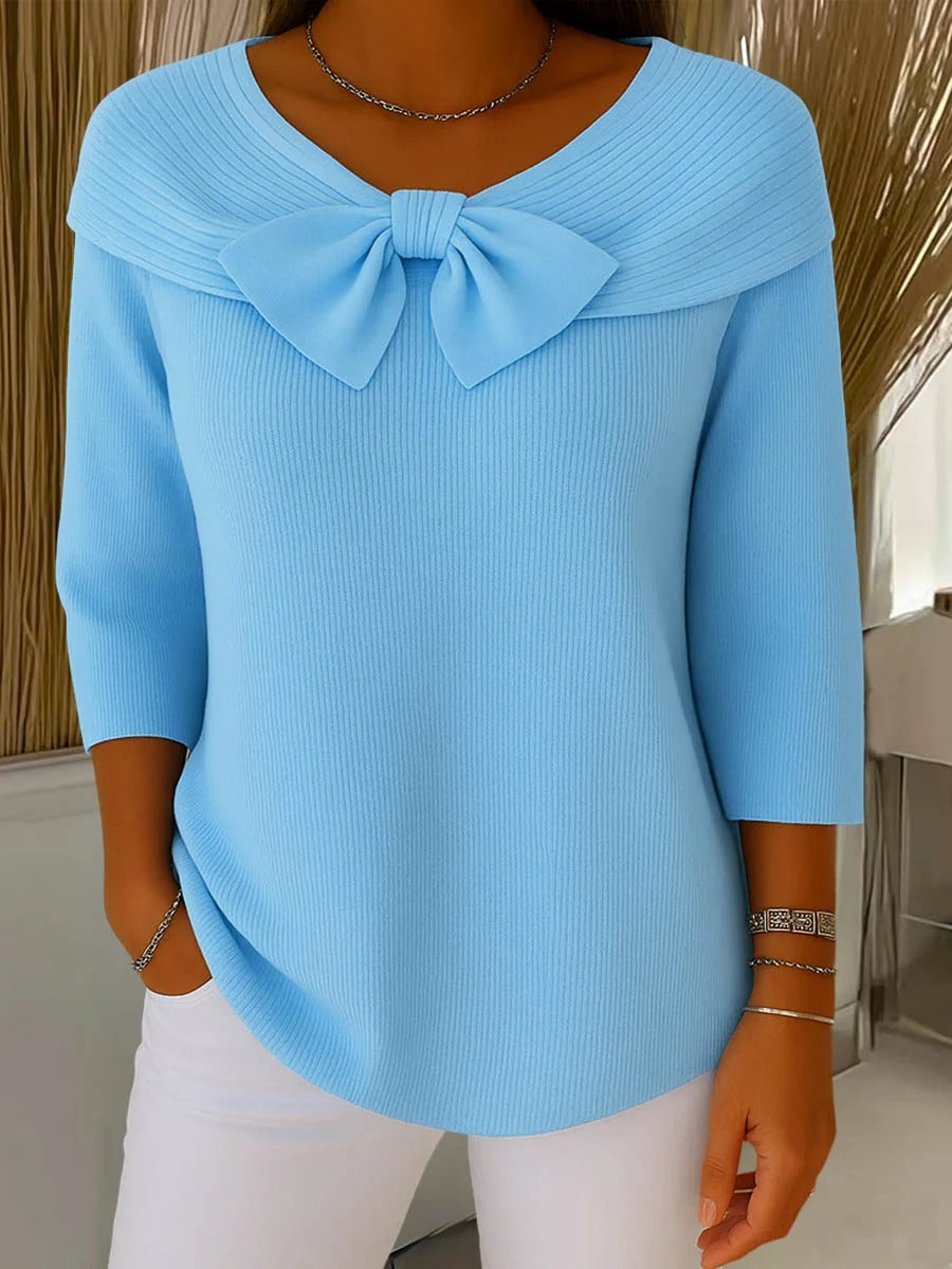 Women's elegant knit sweater with chic bow detail, perfect for autumn fashion.