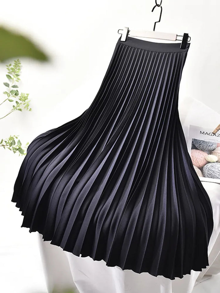 Fashionable women in a long, flowing pleated maxi skirt, ideal for an elegant spring outfit.