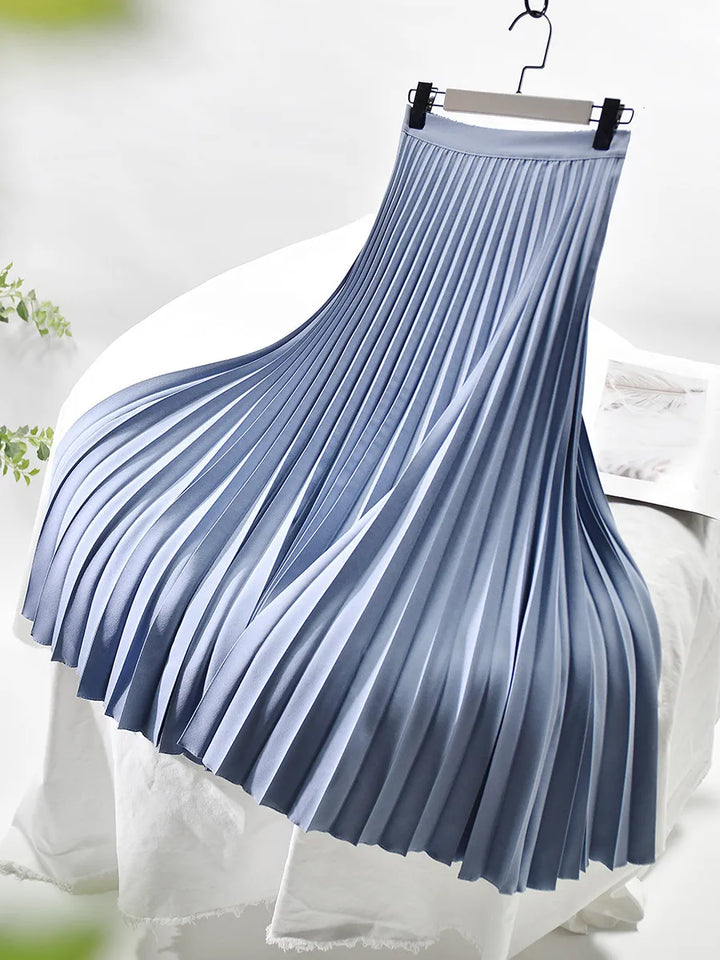 Back view of a women's long pleated skirt, emphasizing its flowy silhouette and elegant drape.