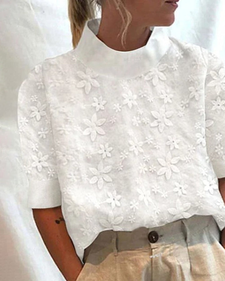 Stylish women's white blouse featuring a sophisticated stand collar and chic floral embroidery, versatile for casual or dressy.