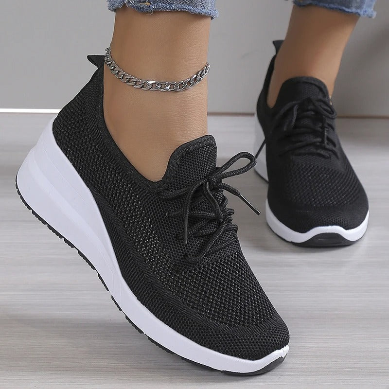 Women's athletic style wedge sneakers, offering an elevated platform for comfort and casual fashion.