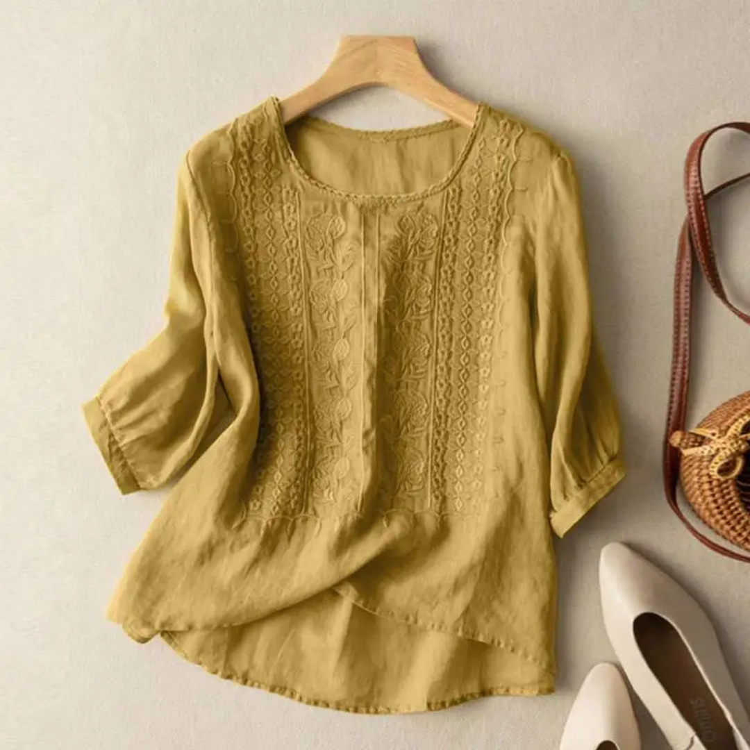 Women's embroidered blouse with vibrant floral details, 3/4 sleeves, and a relaxed fit, perfect for elegant casual wear.