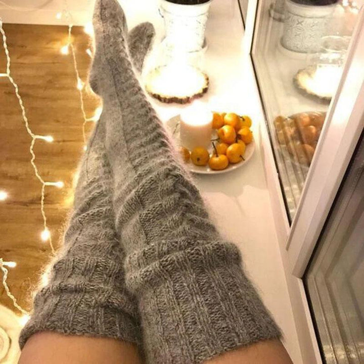 Women's extra long warm knitted over-knee socks in a rich burgundy color, perfect for winter fashion.
