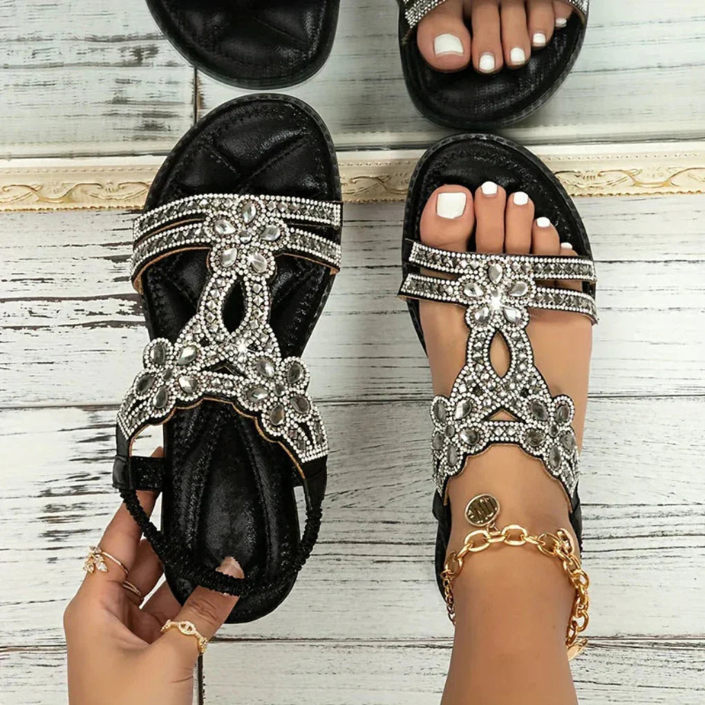 Close-up of a women's flat sandal with intricate floral embellishments, ideal for spring fashion