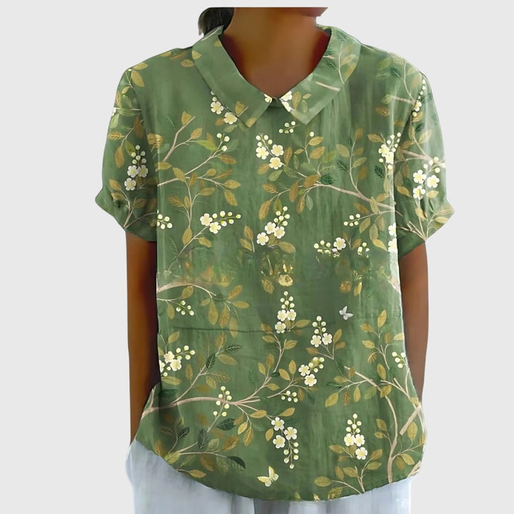 Woman in a relaxed fit floral blouse, effortlessly stylish & comfortable for spring activities.